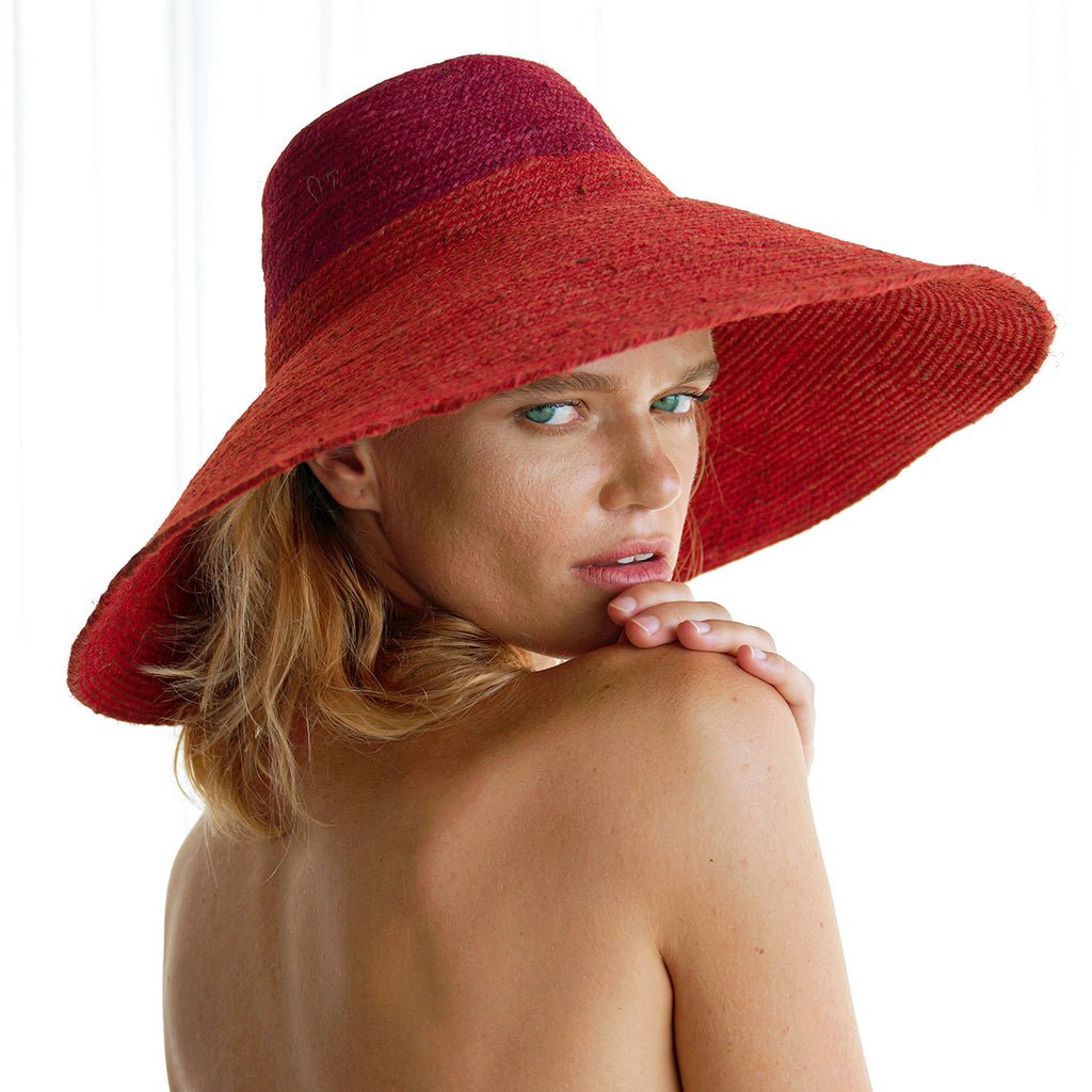 Duo color tone handwoven beach straw hat in red and maroon brim color, handmade from natural jute straw by local artisan in Bali. Handmade vacation wide-brim hat with domed down brim for maximum sun protection. Sustainably made by female artisan community in Indonesia for resort vacation season.