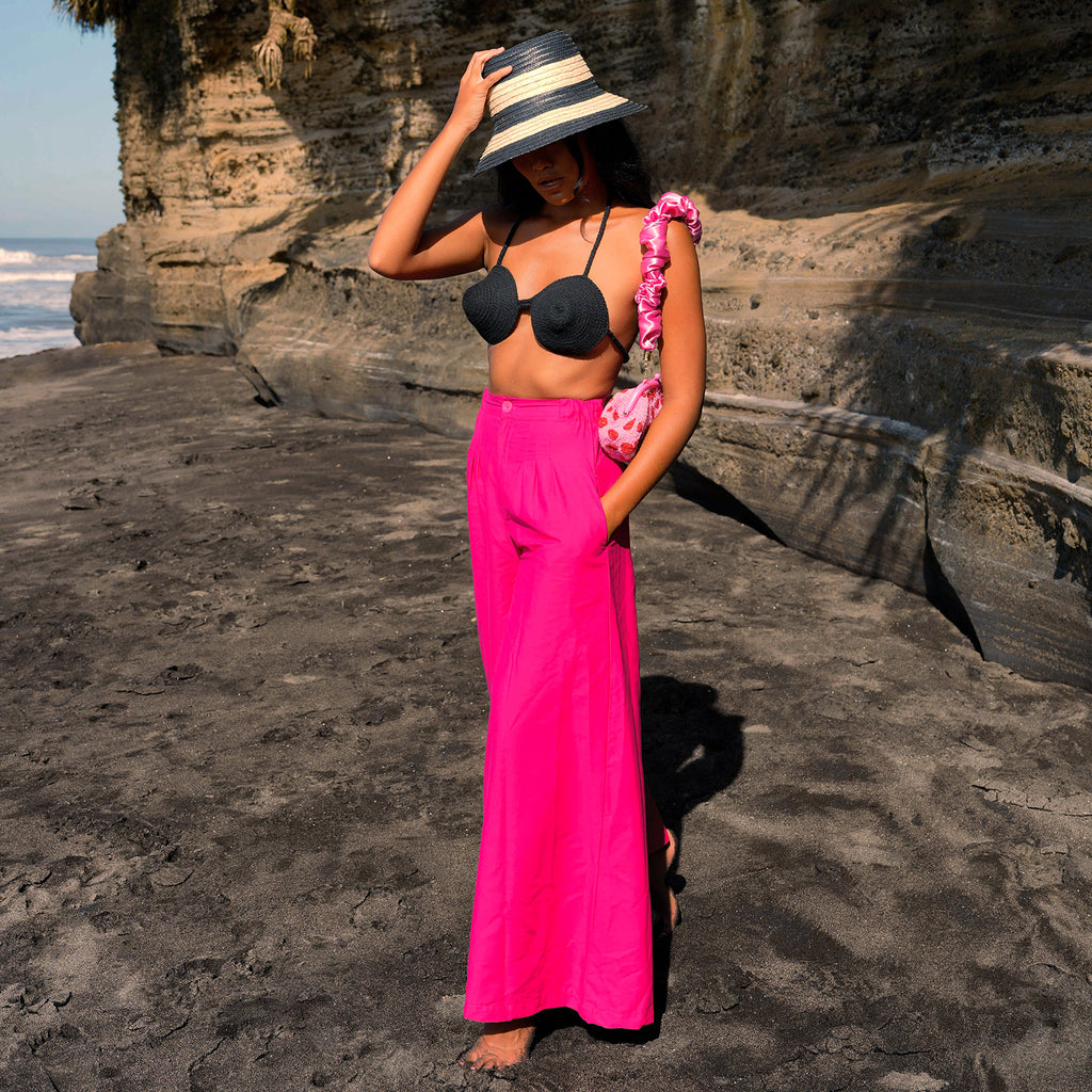 Taylor pants in hot barbie pink are a classic piece, made for a perfect day under the warm sun. Made with comfy and light-weight cotton fabric, these pleated pants have a high rise and slim fit along the waist with a wide-leg silhouette. Wear yours with BrunnaCo’s rope bralette or a cropped top.