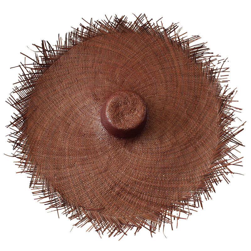 BrunnaCo Amora Frayed Wide-Brim Straw Hat in Chestnut Brown. This AMORA hat showcases classic style, updated for the modern era with its oversized and frayed straw design. With a versatile chestnut brown hue and a wide brim, create a bold statement as you go while at the same time keeping you protected from the sun's harsh rays. The perfect addition to any summer wardrobe!
