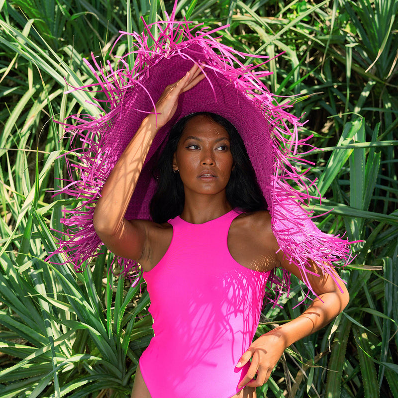 BrunnaCo's AMORA hat showcases classic style, updated for the modern era with its oversized and frayed straw design. With a hot pink hue and a wide brim, create a bold statement as you go while at the same time keeping you protected from the sun's harsh rays. The perfect addition to any summer wardrobe!