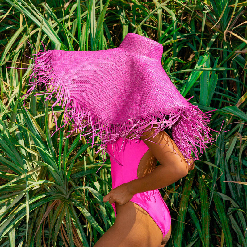 BrunnaCo's AMORA hat in Hot Pink showcases classic style, updated for the modern era with its oversized and frayed straw design. With a hot pink hue and a wide brim, create a bold statement as you go while at the same time keeping you protected from the sun's harsh rays. The perfect addition to any summer wardrobe!