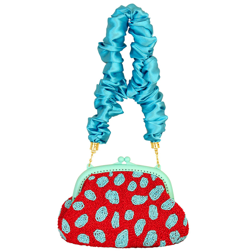 BrunnaCo Arnoldi Ariela Handbeaded clutch in red and turquoise blue color is an artisanal handmade piece by female artisans in Bali. This handbag clutch is carefully and sustainably made using glass beads in playful polka dot pattern.