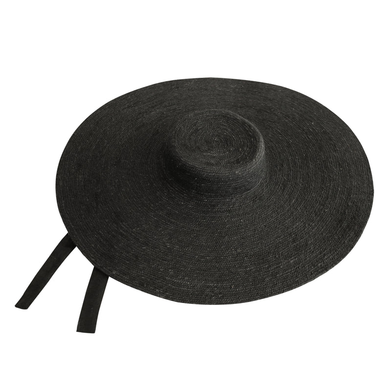 LOLA Wide Brim Jute Straw Hat In Black. Braided meticulously by artisans in Gianyar, Bali from natural Jute material, this sweet hat offers both comfort and elegance. Designed with ideal thickness and weight that allow its brim to be easily folded, stretched, and styled, making it easy to take to any holiday trips or summer vacation.