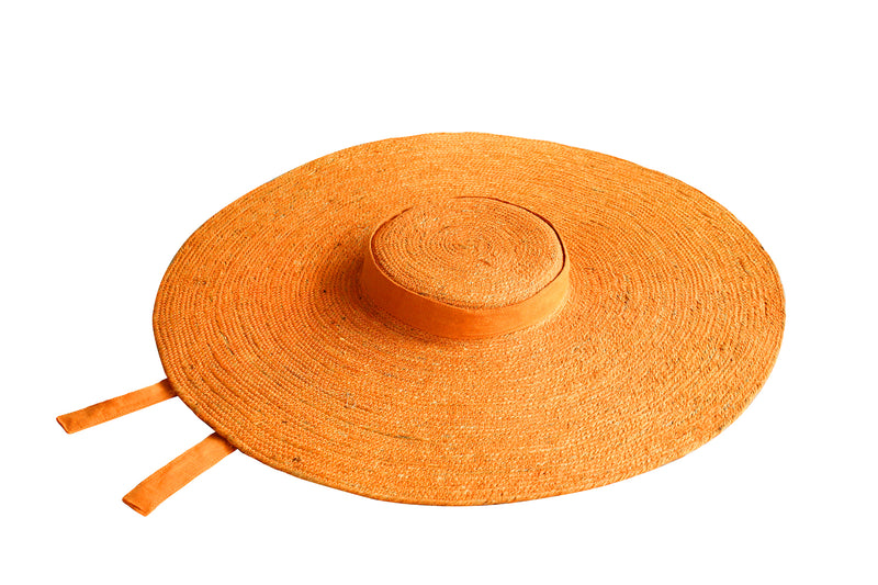 LOLA Wide Brim Jute Straw Hat In Orange. Braided meticulously by artisans in Gianyar, Bali from natural Jute material, this sweet hat offers both comfort and elegance. Designed with ideal thickness and weight that allow its brim to be easily folded, stretched, and styled, making it easy to take to any holiday trips or summer vacation.