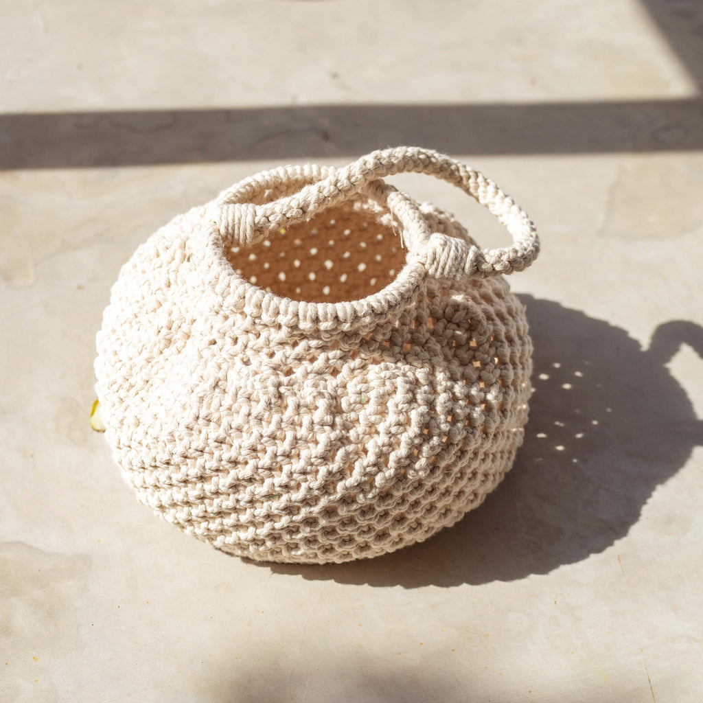 Naga Macrame Beach Bucket Bag. A stylish and eco-friendly macrame beach bag by BrunnaCo, featuring intricate woven patterns, durable handles, and spacious interior, perfect for carrying your beach essentials in sustainable style