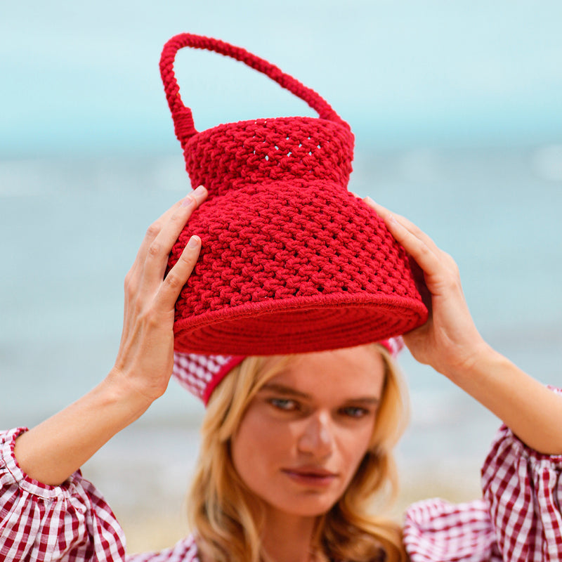 Petite Naga Macrame Crochet Bucket Beach Bag in Red. This bucket bag is made with hand-dyed macrame cotton ropes by our female artisan community in Java, Indonesia. It takes at least around 80 hours to make each bag, and this project helps to provide jobs and security for the artisans in this region.