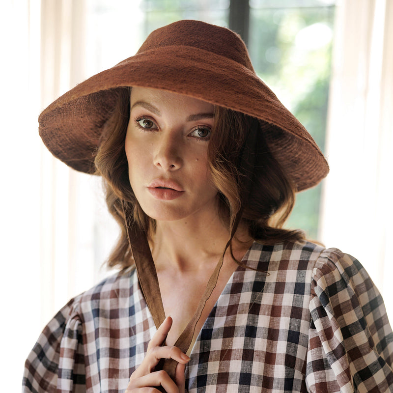 Reign Jute Beach Hat in Burnt Sienna. REIGN is a classic multi-functional hat with downturned brim made with natural jute straw and modern structural shape. This hat was made to accompany you from the great outdoors to chic dinner and anywhere you travel in between.