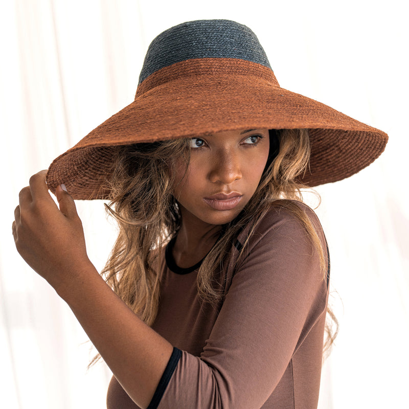 Duo color tone handwoven beach straw hat in Burnt Sienna and Black color, handmade from natural jute straw by local artisan in Bali. Handmade vacation wide-brim hat with domed down brim for maximum sun protection. Sustainably made by female artisan community in Indonesia.