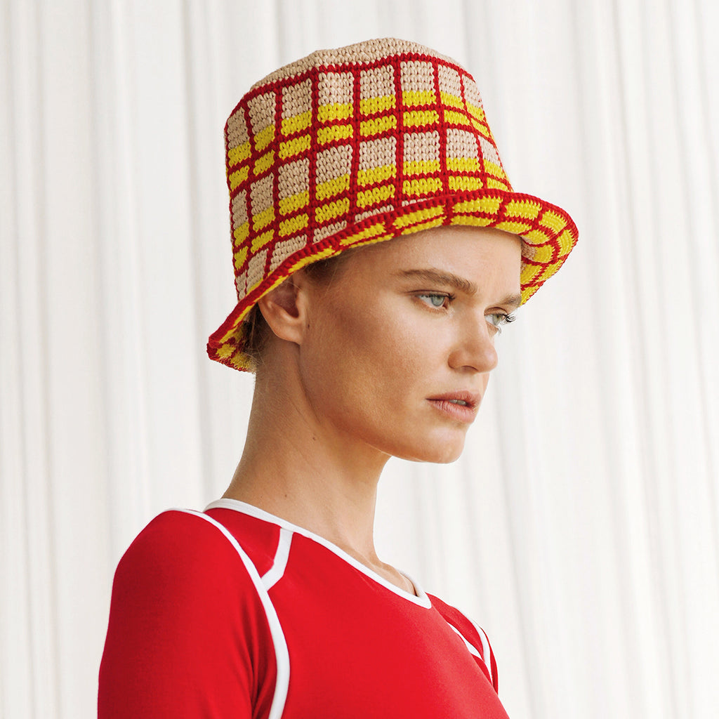 Schoolgirl Plaid Crochet Hat. Hand-crocheted by female artisans in Java, Indonesia, this SCHOOLGIRL plaid crochet hat is a reminder of the beautiful feeling of being outdoors. Its fresh hot red and calming beige color invites us to celebrate the seasons in the sun.