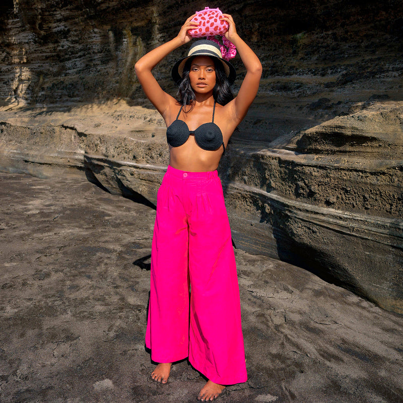 Taylor pants in hot barbie pink are a classic piece, made for a perfect day under the warm sun. Made with comfy and light-weight cotton fabric, these pleated pants have a high rise and slim fit along the waist with a wide-leg silhouette. Wear yours with BrunnaCo’s rope bralette or a cropped top.